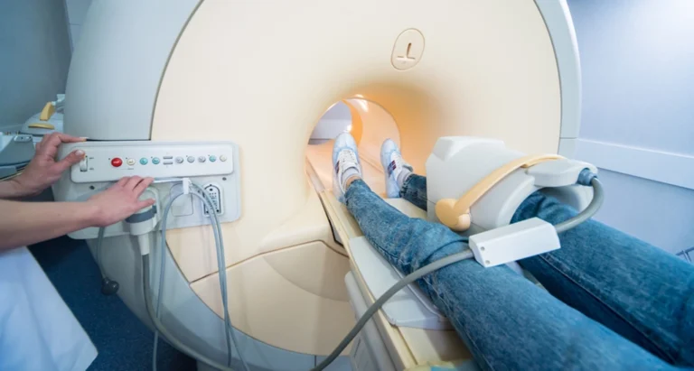 MRI Technologist Operating A Knee MRI For A Female Patient