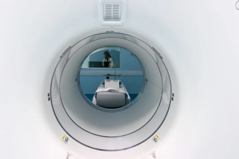 Inside Of An MRI Scan Machine With MRI Technologist In The Control Room