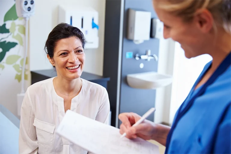 Female Patient Discussing MRI Scan With Female Technologist Before Her Appointment