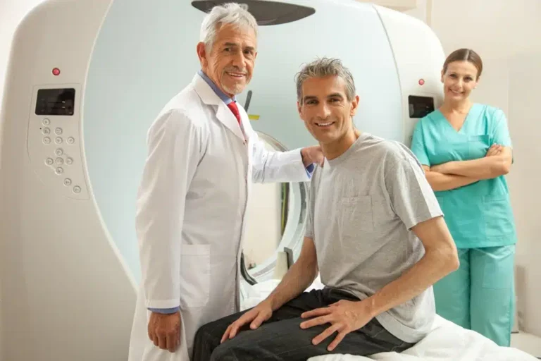 CT Technologist And Radiologist Smiles With Patient Before A CT Scan