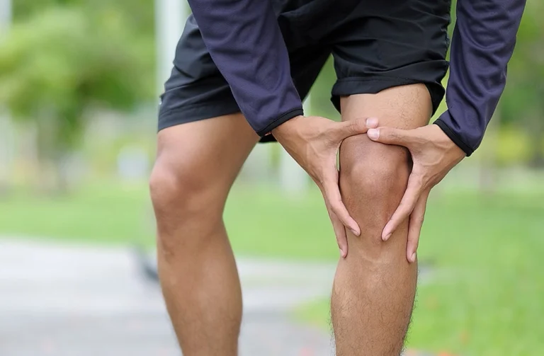 Male Runner Experiencing Knee Pain After A Jog In The Park