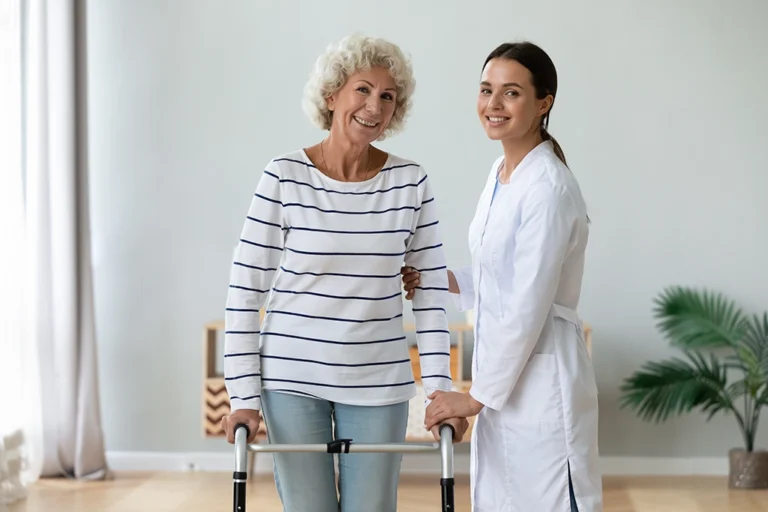 Technologist Helping Elderly Woman With Walker During Appointment